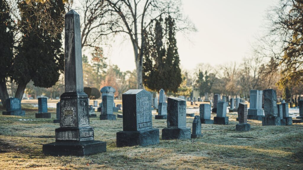 A tombstone-lined cemetery with trees scattered throughout.