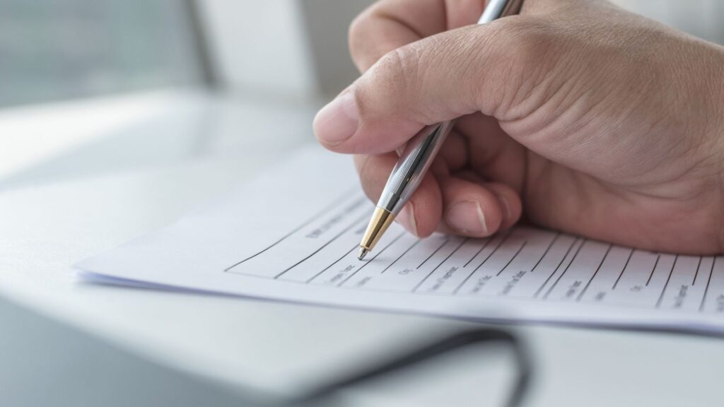 Persona firmando un documento legal.