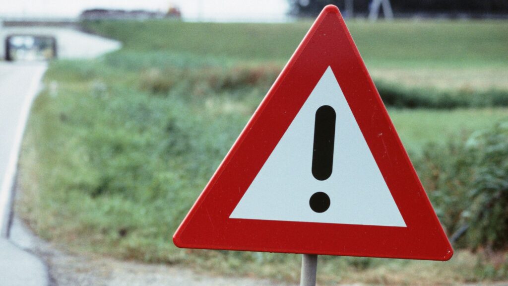 Una señal de advertencia al lado de una carretera. 