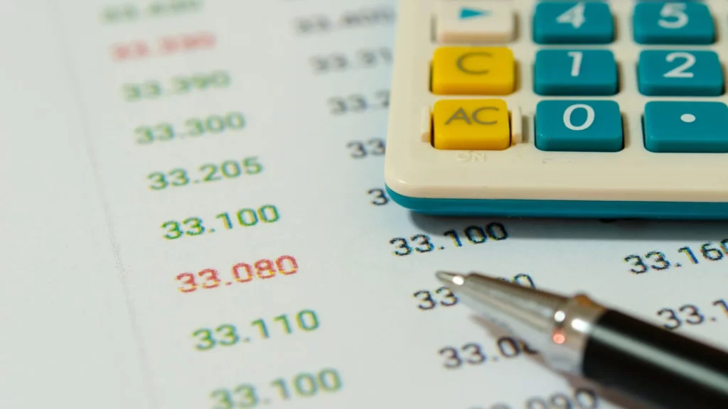 A sheet of paper with varying prices and a pen and calculator.