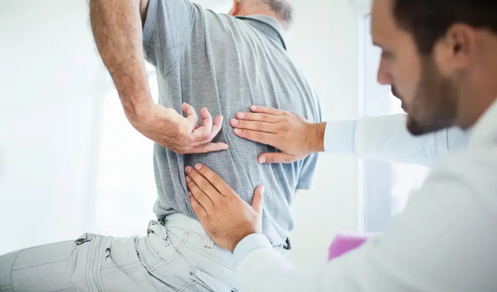 An old man with a back injury getting checked out by a doctor.